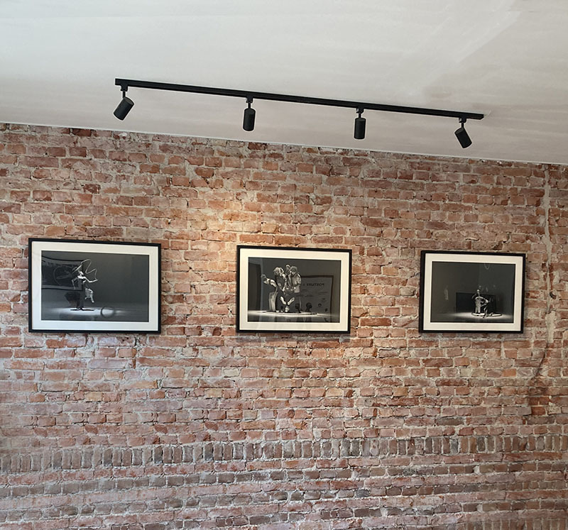 a view of a brick wall with 3 pictures black and white